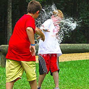 kid throwing a water balloon at another kid