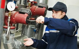 Commercial plumber inspecting valve assembly