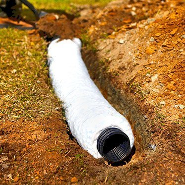 a worker installs a french drain