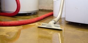 flooded basement being cleaned by a vacuum