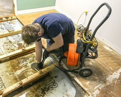 water cleanup technician using a vacuum