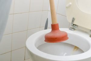 unclogging a toilet with a plunger