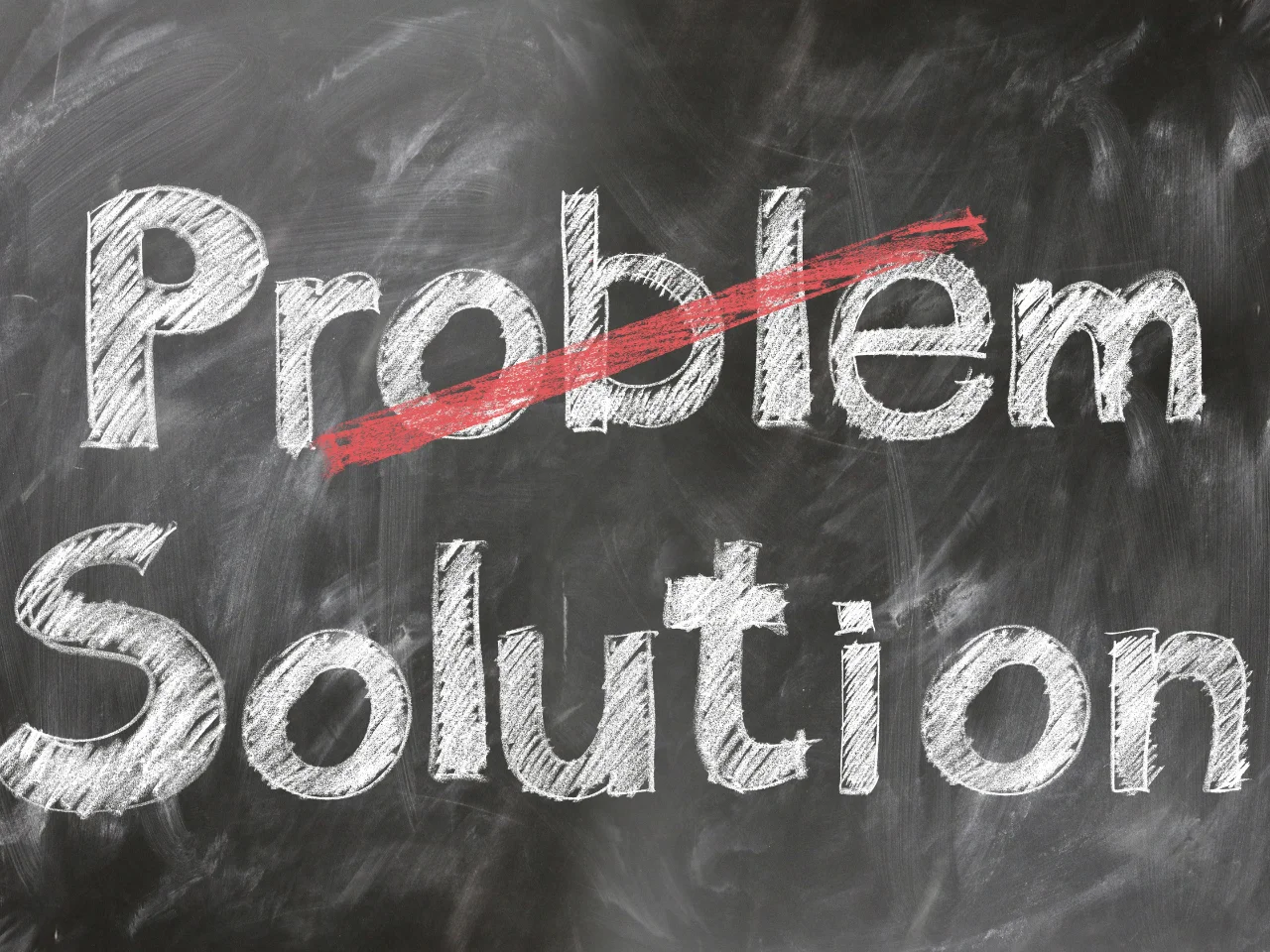 The word Problem is written in chalk on a blackboard with a red line striking through it, and below it, the word Solution is written in large white letters.