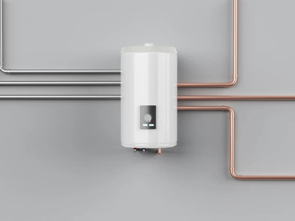 A white water heater mounted on a light gray wall with three metal pipes on the left and three copper pipes on the right, all connecting to the unit.
