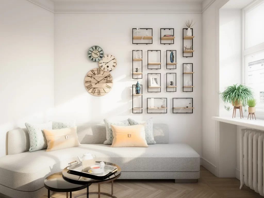 Bright living room with a modern light gray sofa, pastel cushions, wall art featuring clocks and shelves with decor, round nesting coffee tables, and a large window with potted plants on the sill.